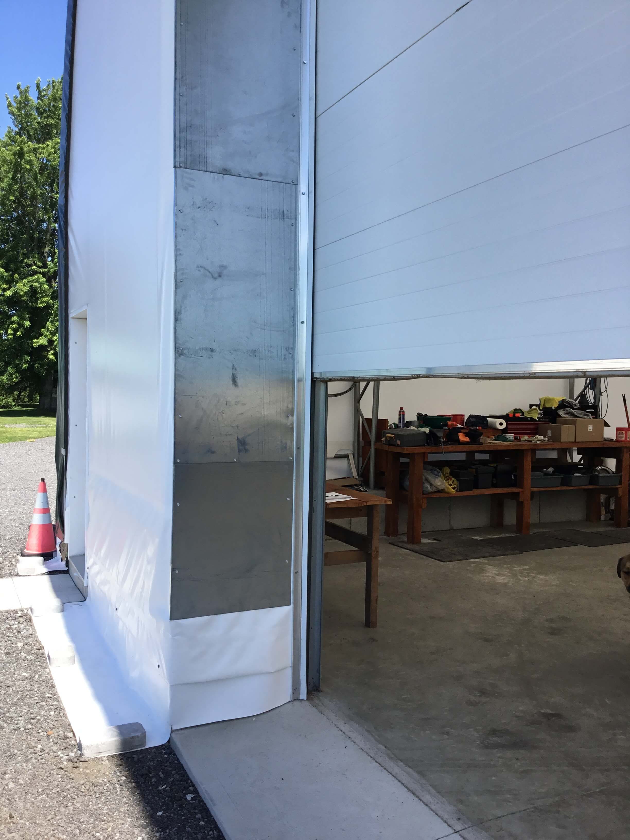 Si la fondation est composée de blocs de béton, ces derniers sont reliés par une plaque de métal. La membrane recouvre alors le côté extérieur du bâtiment pour assurer une belle finition. 